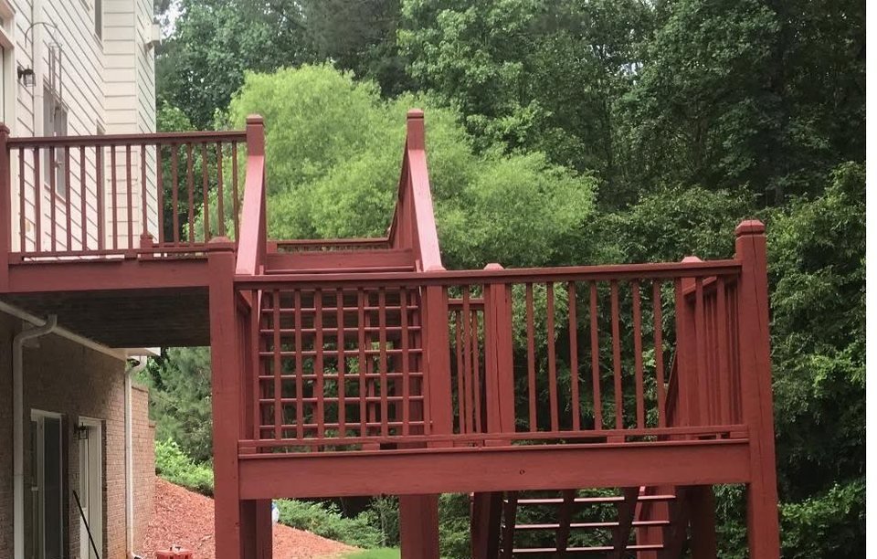 Two-level wooden deck with lattice and railings freshly stained a deep oxblood red